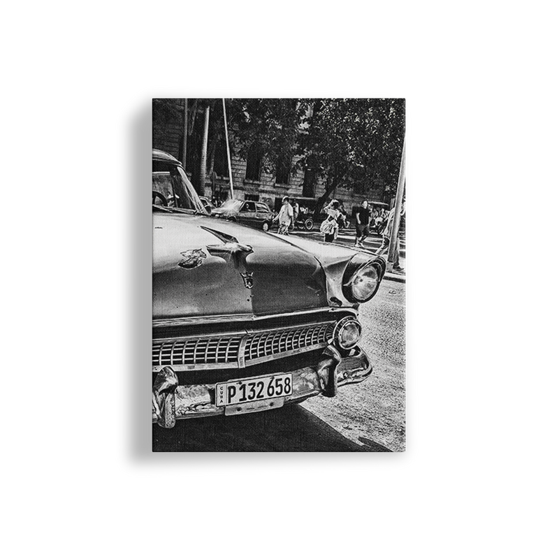 Black and white photo of a vintage car with people in the background