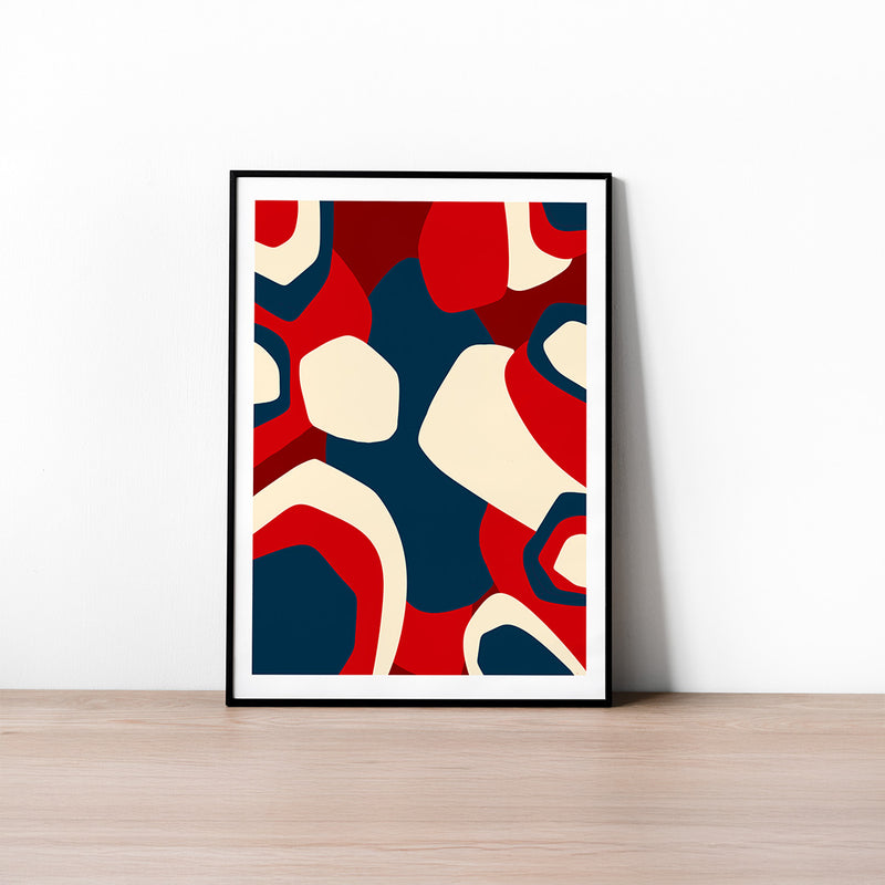 Framed abstract art print with red, blue, and beige colors on a white wall.